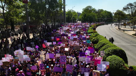 Aerial-view-low-over-a-crowd-of-feminists-marching-on-International-Women's-Day,-spring-day-in-Mexico-city