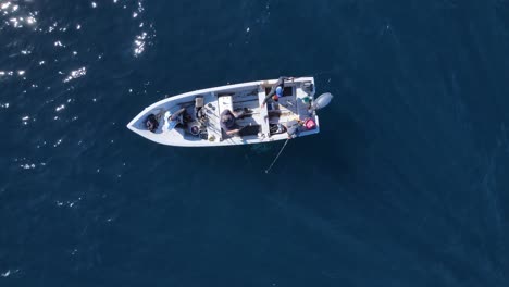 Tight-birdseye-view-of-fishermen-arranging-boat-in-open-ocean-on-sunny-day