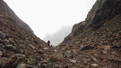 Un-Grupo-De-Escaladores-Que-Ascienden-Entre-Dos-Picas-Entre-Las-Nubes-En-Montañas-Rocosas
