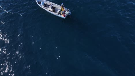Absteigende-Luftaufnahme-über-Fischern-Auf-Einem-Boot-Im-Tiefblauen-Offenen-Ozean