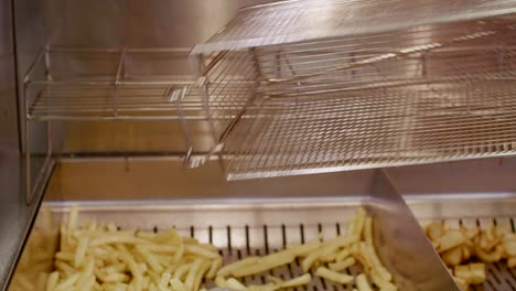 French-fries-taken-out-of-oil-and-placed-on-grate-in-fast-food-kitchen