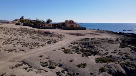 Mexican-coastal-villa-on-sea-cliffs-by-open-ocean-on-beautiful-sunny-day