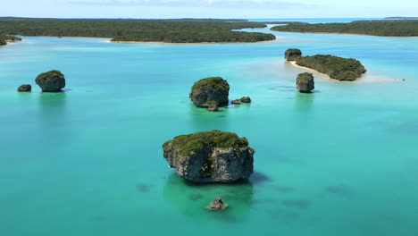 Upi-Bay-on-the-Isle-of-Pines-is-dotted-with-small-rock-islands---aerial-parallax