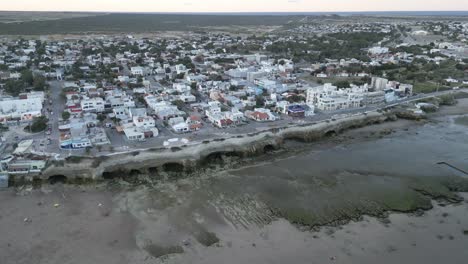 Beach-Shore-of-Las-Grutas,-Argentine-Patagonia,-Resort-Town-of-Seasonal-Whales,-Aerial-Drone-Above-Coastline-and-Cityscape