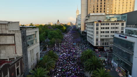 Aerial-view-over-females-marching-on-International-Women's-Day,-sunset-in-Mexico-city