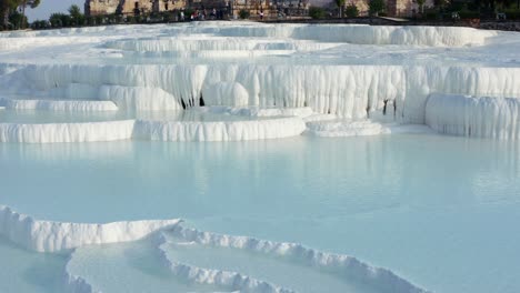 Aerial-view-,-Natural-travertine-pools-and-terraces-in-Pamukkale,-Cotton-castle-in-Turkey,-UNESCO-World-Heritage,-Denizli,-Pamukkale-geothermal-springs,-travertine-terraces,-ancient-city-of-Hierapolis