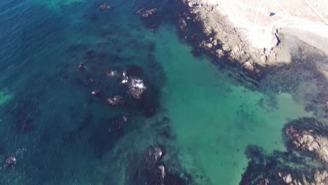 Aerial-tilt-up-revealing-deep-blue-ocean-and-desert-coastline