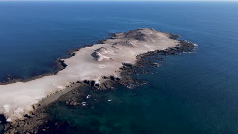 Aerial-orbit-around-Isla-la-asuncion-desert-rocky-island-on-Mexico-coast