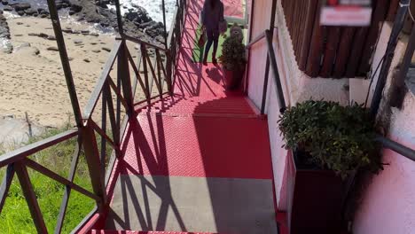 Eine-Frau-Steigt-Eine-Große-Treppe-Hinab,-Ihre-Schritte-Werden-Von-Einem-Roten-Teppich-Geleitet