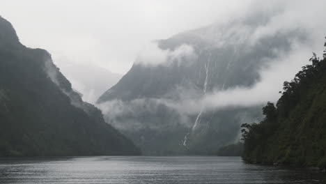 Milford-Sound-Cruise,-distant-waterfalls-obscured-by-mysterious-misty-clouds
