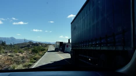 Un-Camión-Destrozado-Y-Volcado-Ralentiza-El-Tráfico-En-Una-Carretera-Desértica