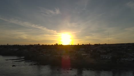 Aufsteigende-Enthüllung-Des-Goldenen-Sonnenuntergangs,-Der-Den-Himmel-Und-Die-Küstenstadt-Bahia-Asuncion,-Mexiko,-Erleuchtet