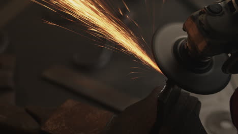 Angle-grinder-re-surfaces-metal-in-vice-whilst-sparks-fly-in-slow-motion