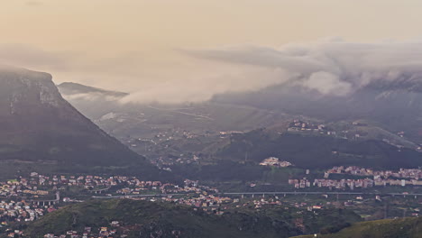 Clouds-below-the-peaks-over-the-valley-city-of-Palermo,-Sicily-at-dawn---time-lapse