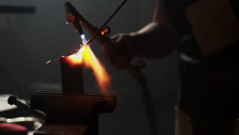 Red-hot-sparks-fly-as-blacksmith-welds-two-pieces-of-metal-together