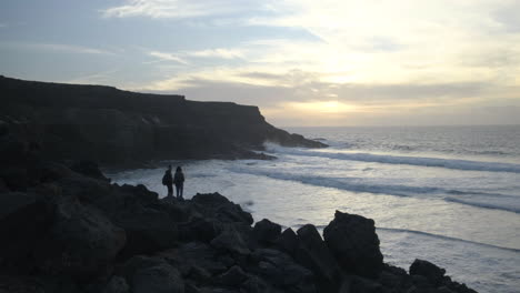Ein-Paar-Betrachtet-Den-Sonnenuntergang-An-Einem-Strand-Auf-Fuerteventura