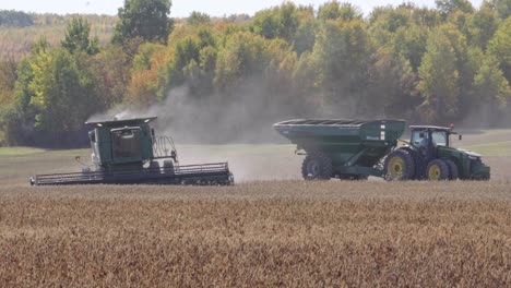 John-Deere-combining-soybeans-on-a-fall-day-with-a-tractor-and-grain-cart-in-the-background