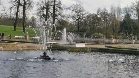 Große-Wasserspiele-In-Einem-Park-In-London-Mit-Möwen-Und-Tauben,-Die-An-Einem-Grauen-Und-Bewölkten-Tag-In-England-Etwas-Im-Wasser-Trinken