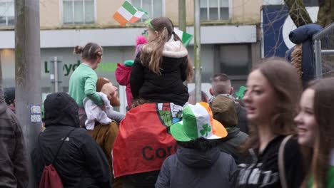 Celebration-on-Cork-City-streets,-people-with-flags-and-clover-hats,-St
