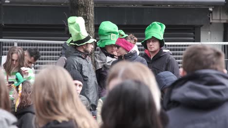 Gruppe-Von-Menschen-Mit-Grünen-Hüten,-Die-Darauf-Warten,-Dass-Die-St.-Patricks-Day-Parade-In-Cork-City-Beginnt