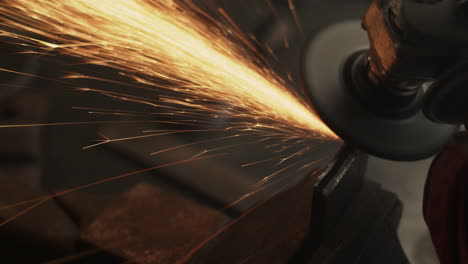 Sparks-fly-as-angle-grinder-grinds-metal-in-blacksmith-workshop-on-a-bench