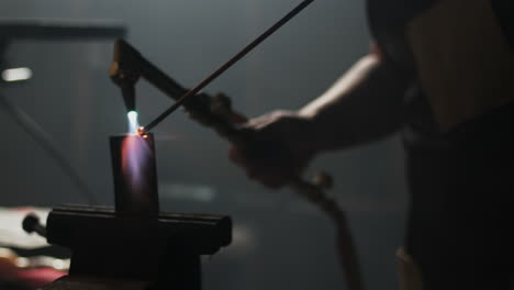 Slow-motion-welding-a-piece-of-metal-in-a-vice-on-a-bench-in-blacksmiths-workshop
