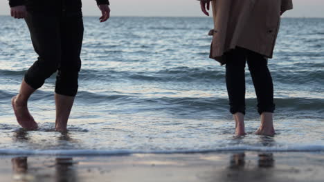 Füße-Eines-Romantischen-Paares,-Das-Den-Strand-Bei-Sonnenuntergang-Genießt