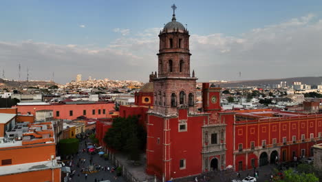 Ascending-aerial-view-in-front-of-the-Templo-de-San-Francisco-church,-sunset-in-Queretaro-city,-Mexico
