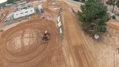 Motocross-track-being-prepared-by-a-tractor-and-rider-training-on-the-ground