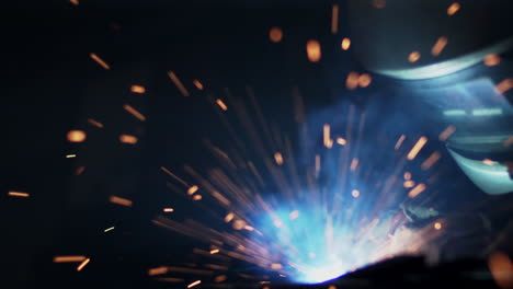 Metal-worker-welds-as-sparks-fly-and-smoke-rises-in-a-workshop