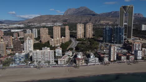 Drone-panorama-shot-showing-skyline-of-Benidorm-Town-in-Spain-with-Puig-Campana-Mountain-in-background