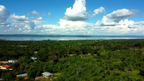 Aerial-View-Of-Ypacarai-Lake-And-Aregua-City-Covered-With-Green-Trees,-Paraguay