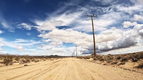 Driving-along-a-lonely-dirt-road-in-the-Mojave-Desert---driver-point-of-view
