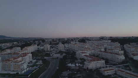 Luftaufnahme-Des-Stadtgebiets-Bei-Sonnenaufgang,-Mit-Der-Bezaubernden-Stadt-Lissabon-Im-Hintergrund,-Mit-Der-Geschäftigen-Bewegung-Der-Züge,-Aufgenommen-In-Hochauflösenden-Drohnenaufnahmen