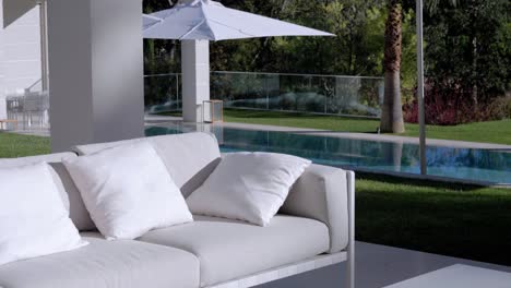 Luxurious-Garden-Bench-with-White-Cushions-and-Magnificent-Pool-in-the-Background