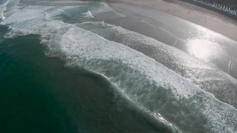 High-aerial-perspective-of-rolling-waves-spread-across-Sintra-Portugal-beach