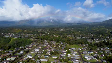 Cinematic-arial-view-of-a-rainbow-Along-Lush-green-jungle-forest-and-mountains-of-Tropical-Kauai,-Hawaii