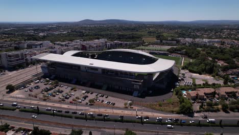 Vista-Aérea-Del-Estadio-De-Rugby-En-Montpellier,-Francia-Con-Un-Atasco-De-Tráfico-En-La-Carretera-Frente-Al-Estadio