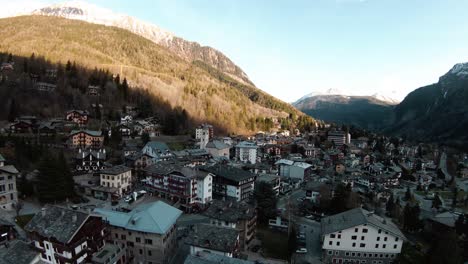 FPV-drone-aerial-over-alpine-mountain-resort-centre-and-church-of-Courmayeur,-Aosta-Valley,-Italy,-Mont-Blanc-Monte-Bianco,-flying-over-houses