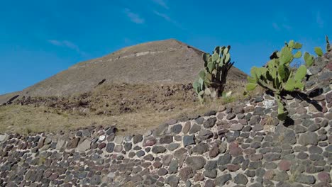 Impresionante-Belleza-De-La-Pirámide-De-Teotihuacan,-Con-El-Magnífico-Cielo-Azul-Arriba,-La-Pirámide-Se-Eleva-En-Medio-De-Un-Exuberante-Entorno-Verde