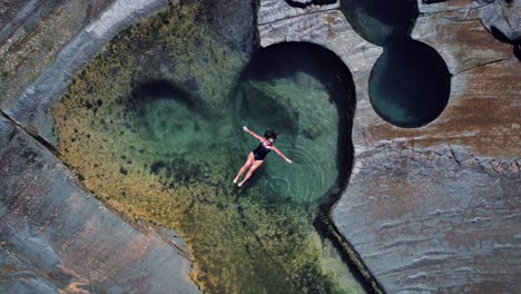Figure-8-Pool,-Australia,-Drone-Ascending-Spiral,-Girl-Floating-in-Pool