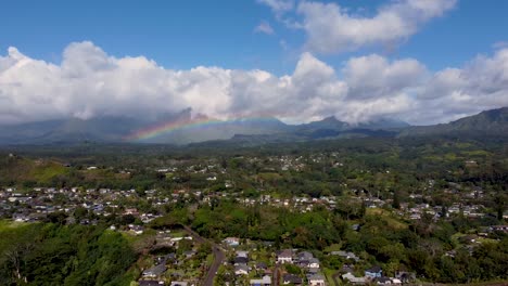 Cinematic-arial-view-with-rainbow-in-cloudy-sky-in-Kauai,-Hawaii