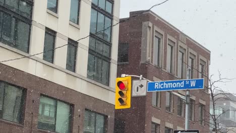 Richmond-Street-West-Sign-at-red-traffic-light-in-Toronto,-Ontario-winter-snow