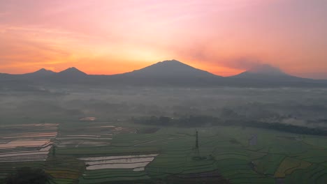 Aerial-view-of-rural-landscape-with-mountain-range-on-the-background-in-sunrise-time