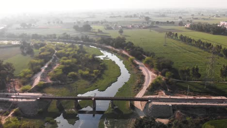 Puente-Ferroviario-Que-Cruza-El-Pequeño-Arroyo-De-Agua-Y-Una-Carretera-Al-Lado.