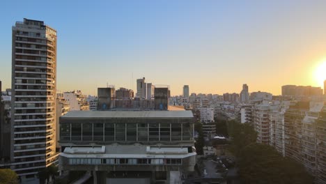 Aerial-jib-down-of-Buenos-Aires-National-brutalist-style-Library-surrounded-by-Recoleta-buildings-at-golden-hour