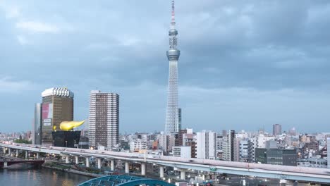 Stunning-city-time-lapse-tilting-up-over-fast-moving-Tokyo-city-and-Skytree-at-dusk