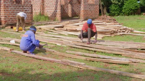 Hombres-Africanos-Clavando-Vigas-De-Madera-En-Un-Sitio-De-Construcción