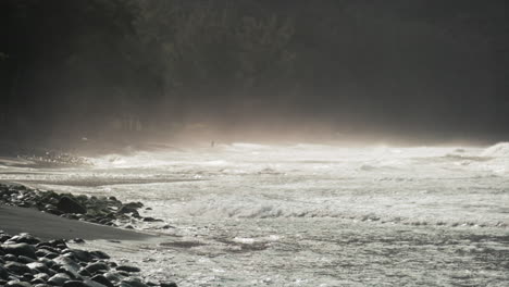 Super-slow-motion-wide-shot-of-fog-covered-black-sand-beach-and-small-waves-from-the-ocean