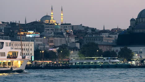 Wunderschöner-Dämmerungsclip-Der-Hagia-Sophia,-Während-Eine-Beleuchtete-Fähre-Am-Goldenen-Horn-In-Istanbul-Entlangfährt